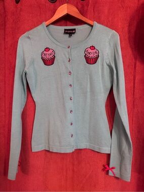 light teal cardigan with cupcake appliqués ‘eat sh*t and die’